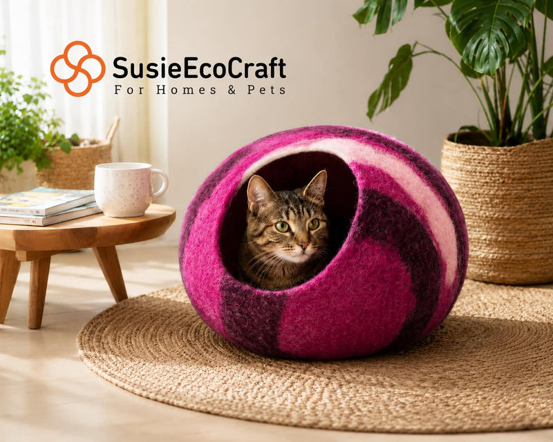 Cat in a colorful felted pet bed with 'SusieEcoCraft' branding in a home setting.